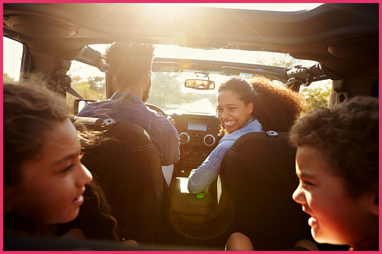 Mom looks back at her kids in card during a road trip; Courtesy onkey Business Images/Shutterstock