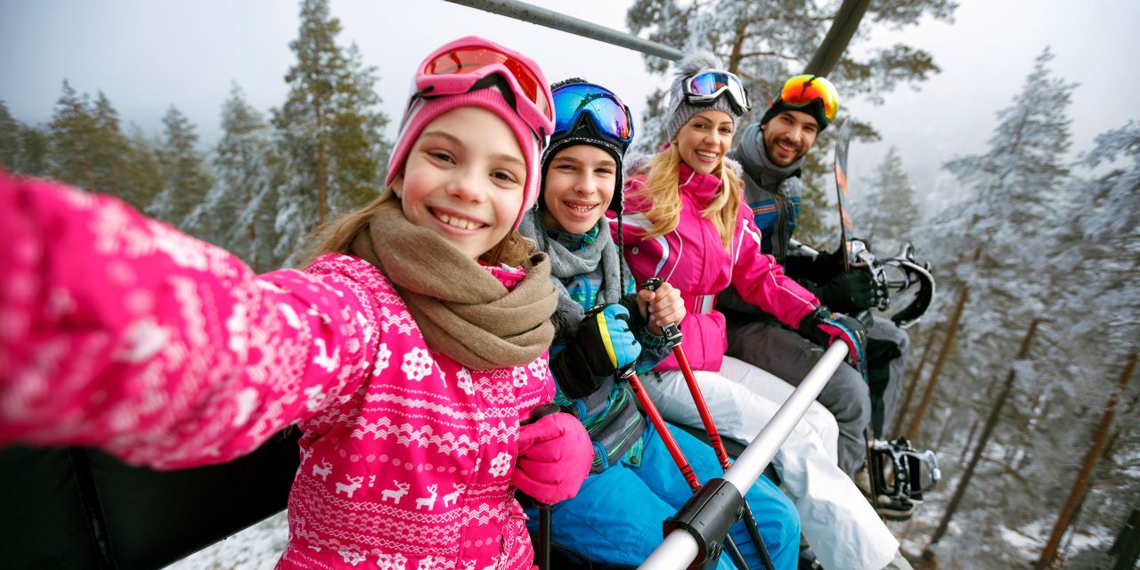 Family Taking Selfie on Ski Lift; Courtesy of Lucky Business/Shutterstock.com