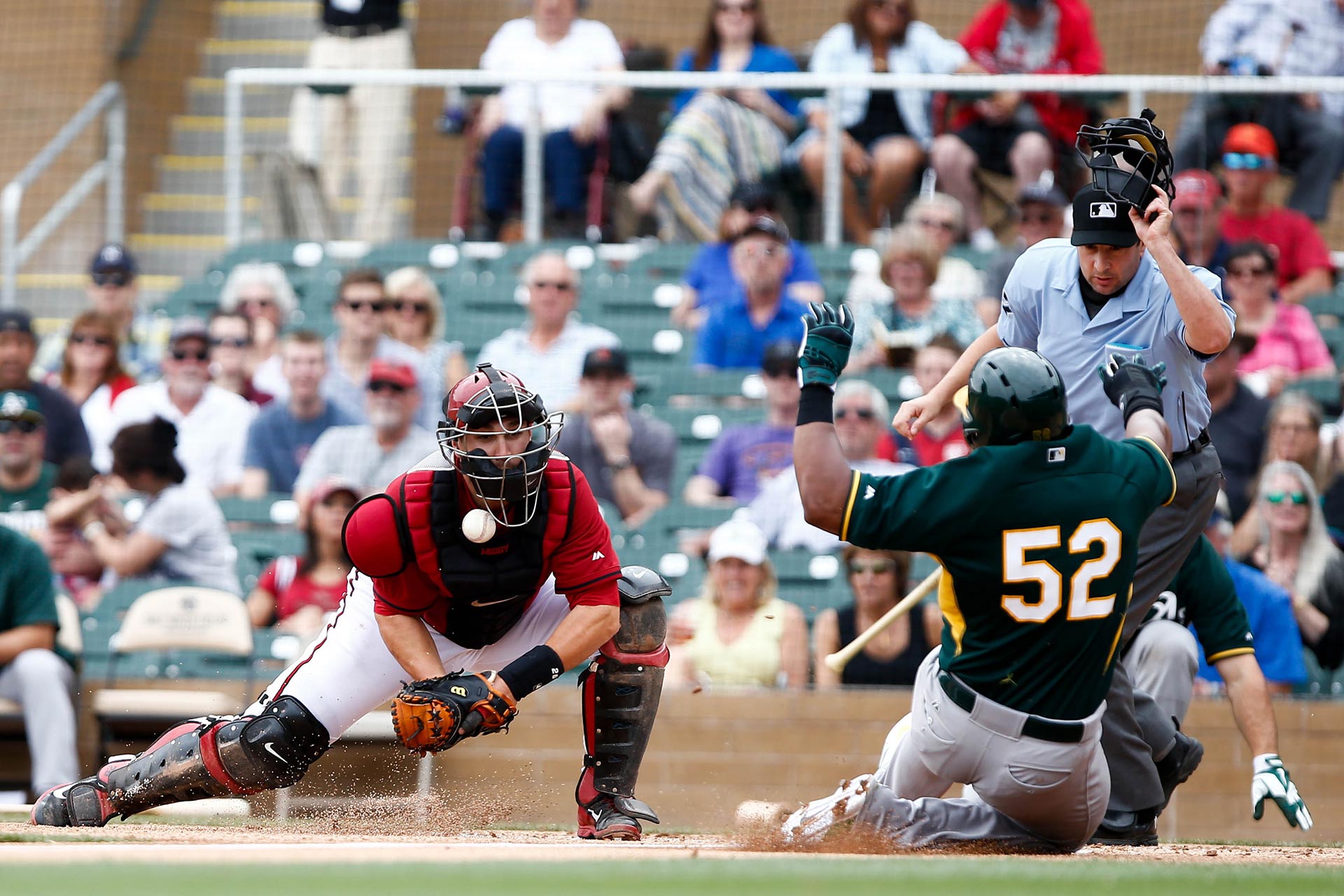 Arizona Diamondbacks catcher, Miguel Montero (26), misses the tag on Oakland Athletics left fielder, Yoenis Cespedes (52), at Salt River Fields at Talking Stick on March 6, 2014 in Scottsdale, Arizona.