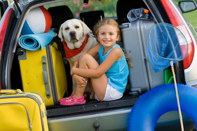 A little girl and her yellow labrador ready to embark on their next camping trip.