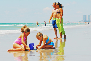 A family playing on the beach at the Holiday Shores Motel in Myrtle Beach.