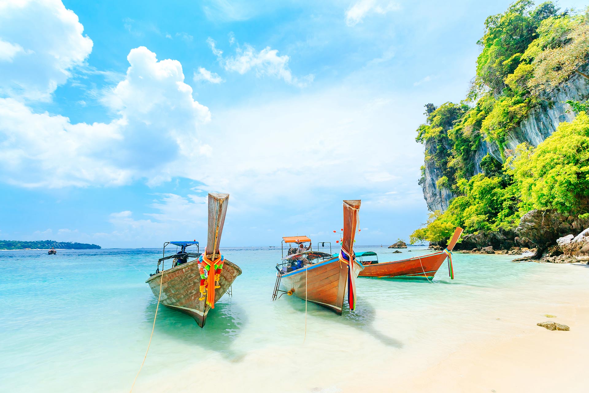 Longtale boat on the white beach at Phuket, Thailand.