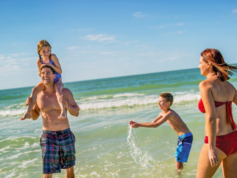 family playing in ocean in siesta beach florida; Courtesy Visit Sarasota