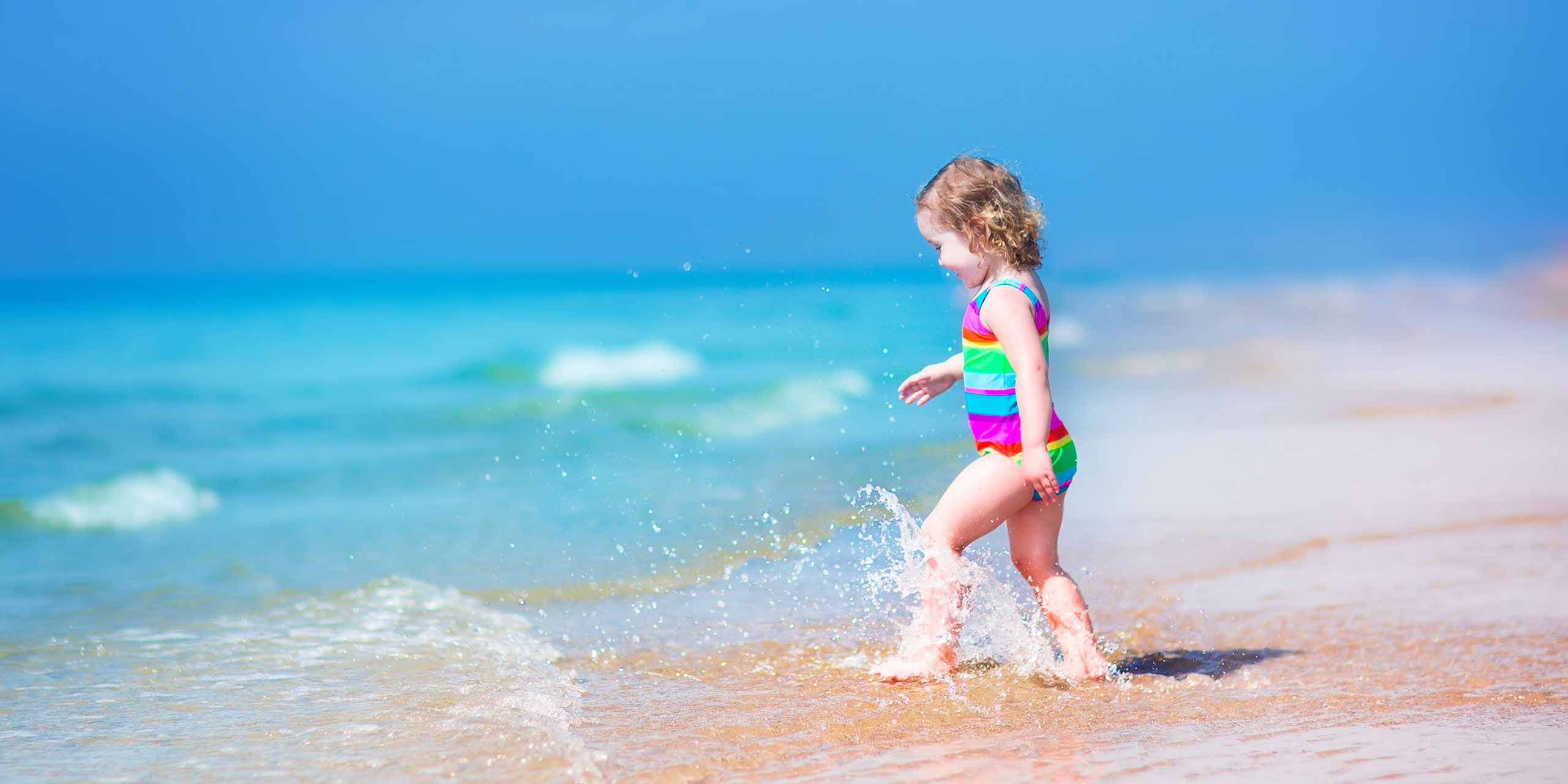Toddler on the Beach; Courtesy of FamVeld/Shutterstock.com