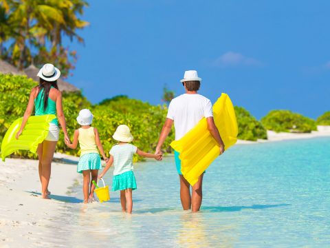 Family Walking on Caribbean Beach; Courtesy of TravnikovStudio/Shutterstock.com
