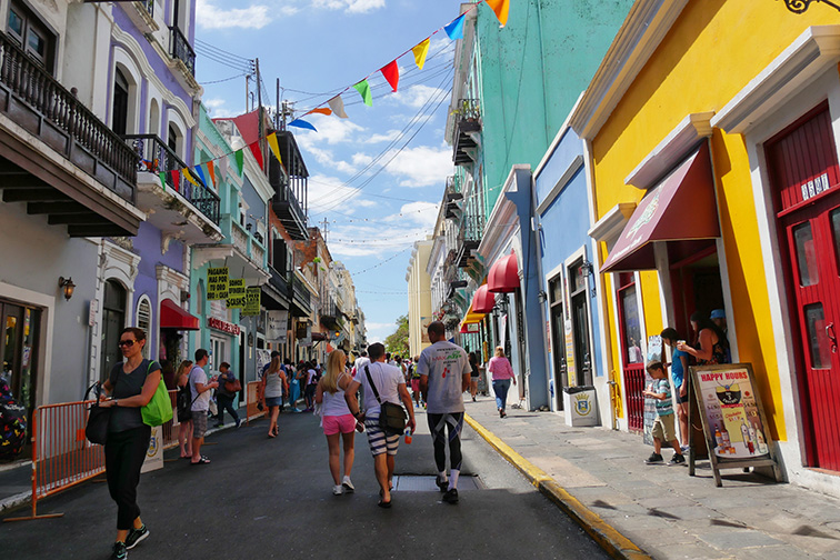 People walking along one of the busy streets of Old San Juan, Puerto Rico; Courtesy of RaksyBH/Shutterstock