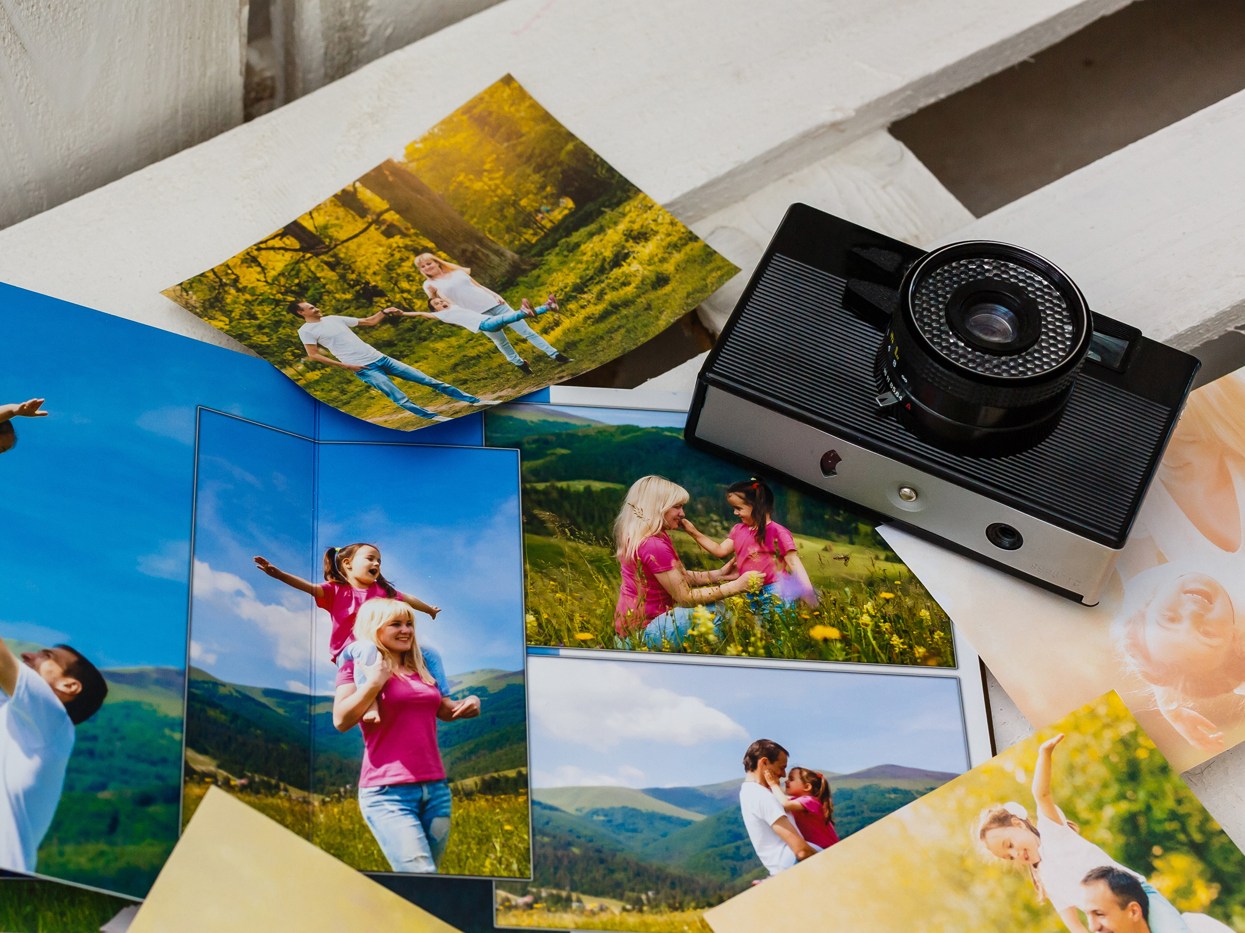 Photo album with photos of travel and vintage old camera on a background ; Courtesy of Andrew Angelov/Shutterstock