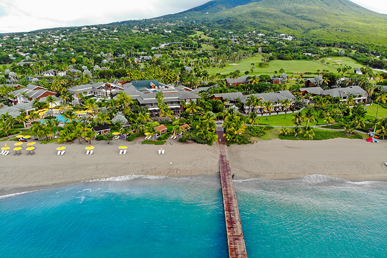 Aerial view of the Four Seasons Nevis hotel, a luxury resort located on Pinney's Beach at the foot of the Nevis Peak volcano and the Caribbean Sea;Courtesy of -/Shutterstock