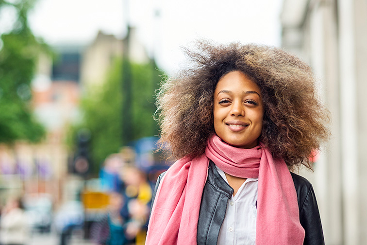 oung smiling woman portrait in the street in London.; Courtesy of pio3/Shutterstock