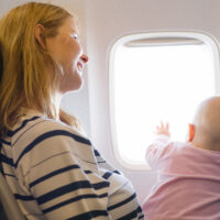 baby on moms lap in flight; Courtesy of Kaspars Grinvalds / Shutterstock
