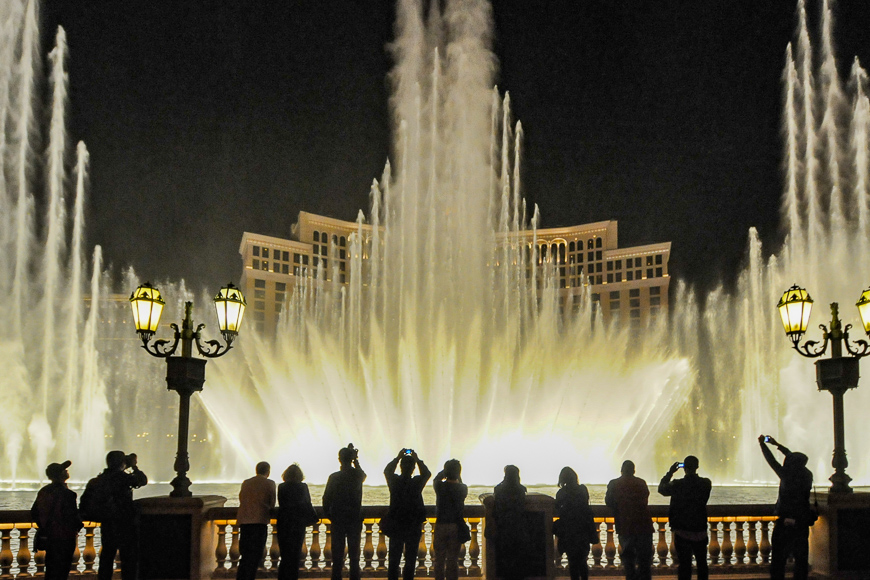 People look at night view of the fountain of Bellagio, Las Vegas, ; Courtesy of Bumble Dee /Shutterstock