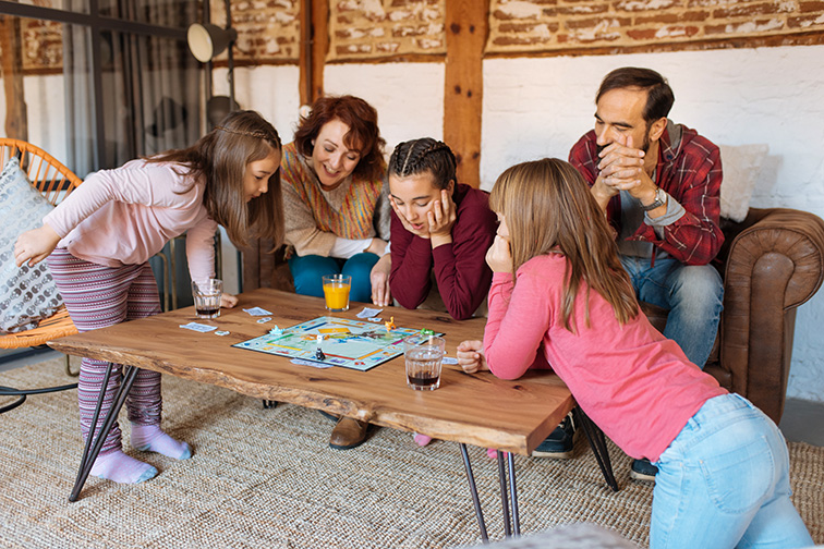 Happy family at home in the couch playing classic table games; Courtesy of David Prado Perucha/Shutterstock