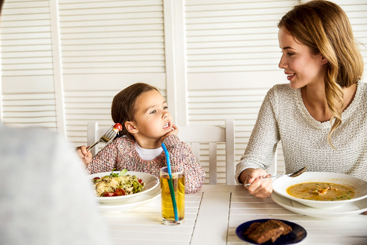 little girl talking at dinner; Courtesy Syda Productions/Shutterstock