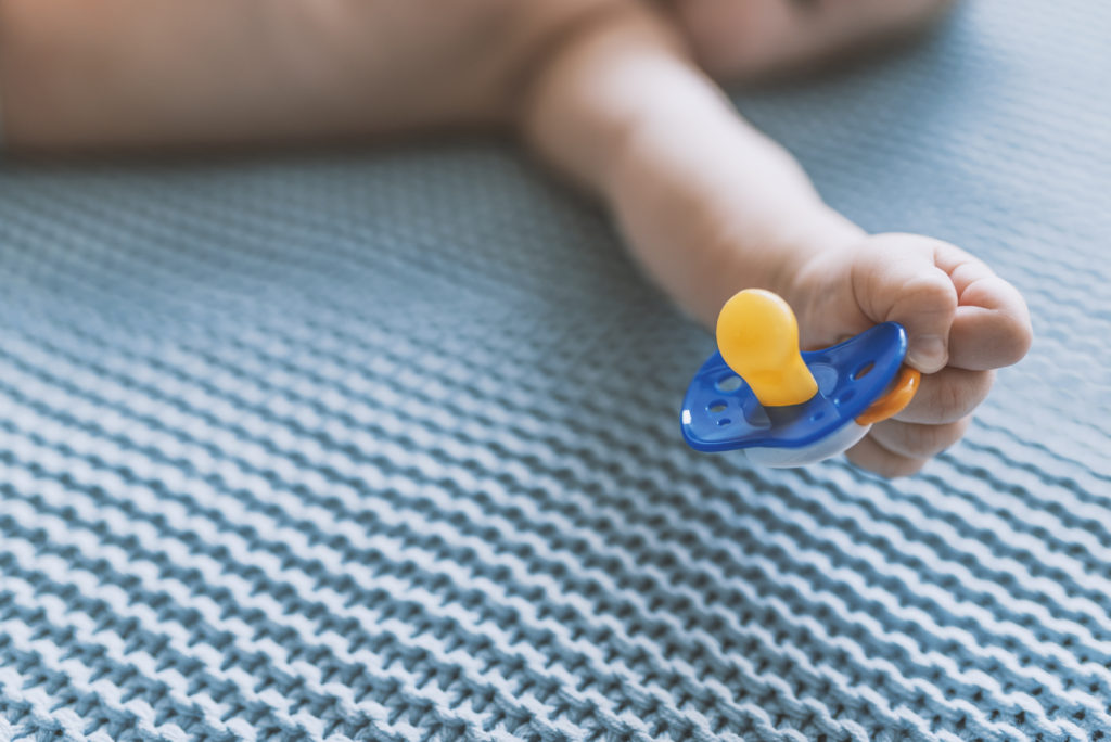 Baby holding pacifier