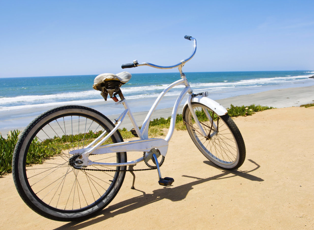 Bike in front of entrance to beach with ocean in background