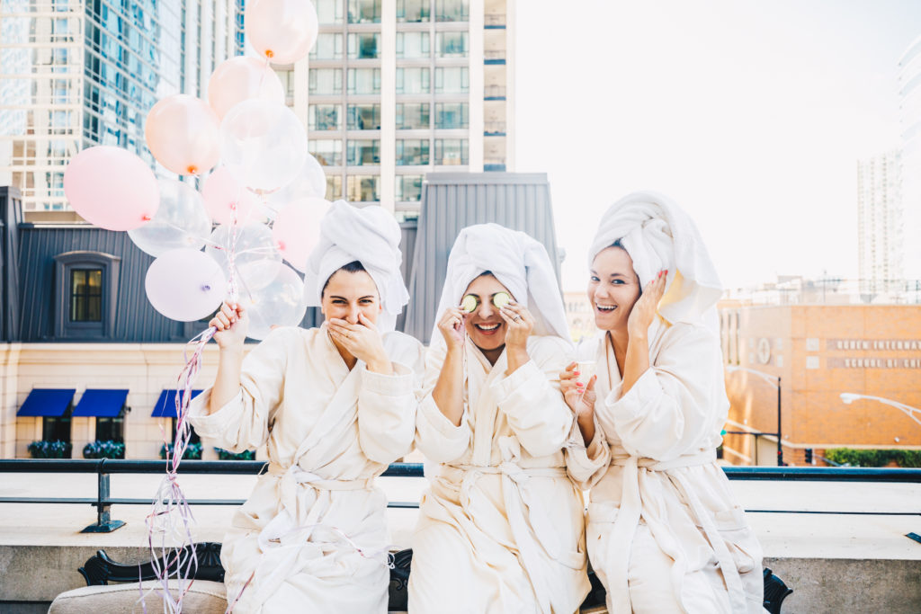Three friends in matching white robes on a rooftop