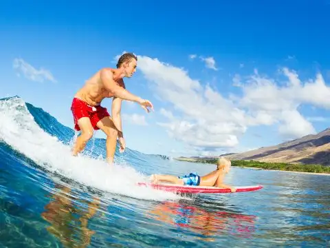 Father and Son Surfing in Hawaii; Courtesy of Epic Stock Media/Shutterstock.com