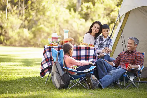 A family enjoying dinner on a camping trip.