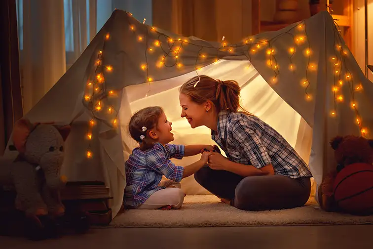 mother and daughter playing at home in a tent;Courtesy of Evgeny Atamanenko/Shutterstock