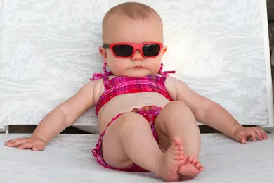 Baby lounging on a lounge chair at the beach.