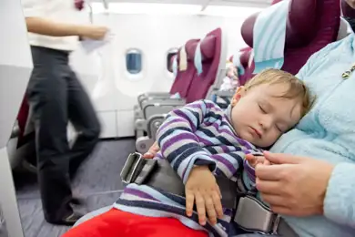Baby sleeping on a plane after a long day.
