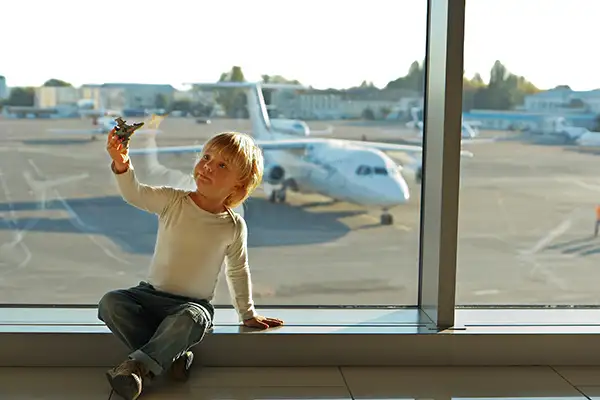 Little boy playing with a toy airplane at the airport
