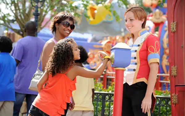 A girl using her MyMagic+ wristband to get onto a ride at Disney World.