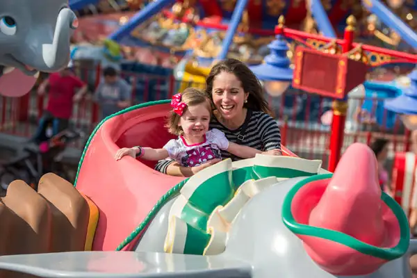 Mother and daughter ride Dumbo the Flying Elephant at Disney World.