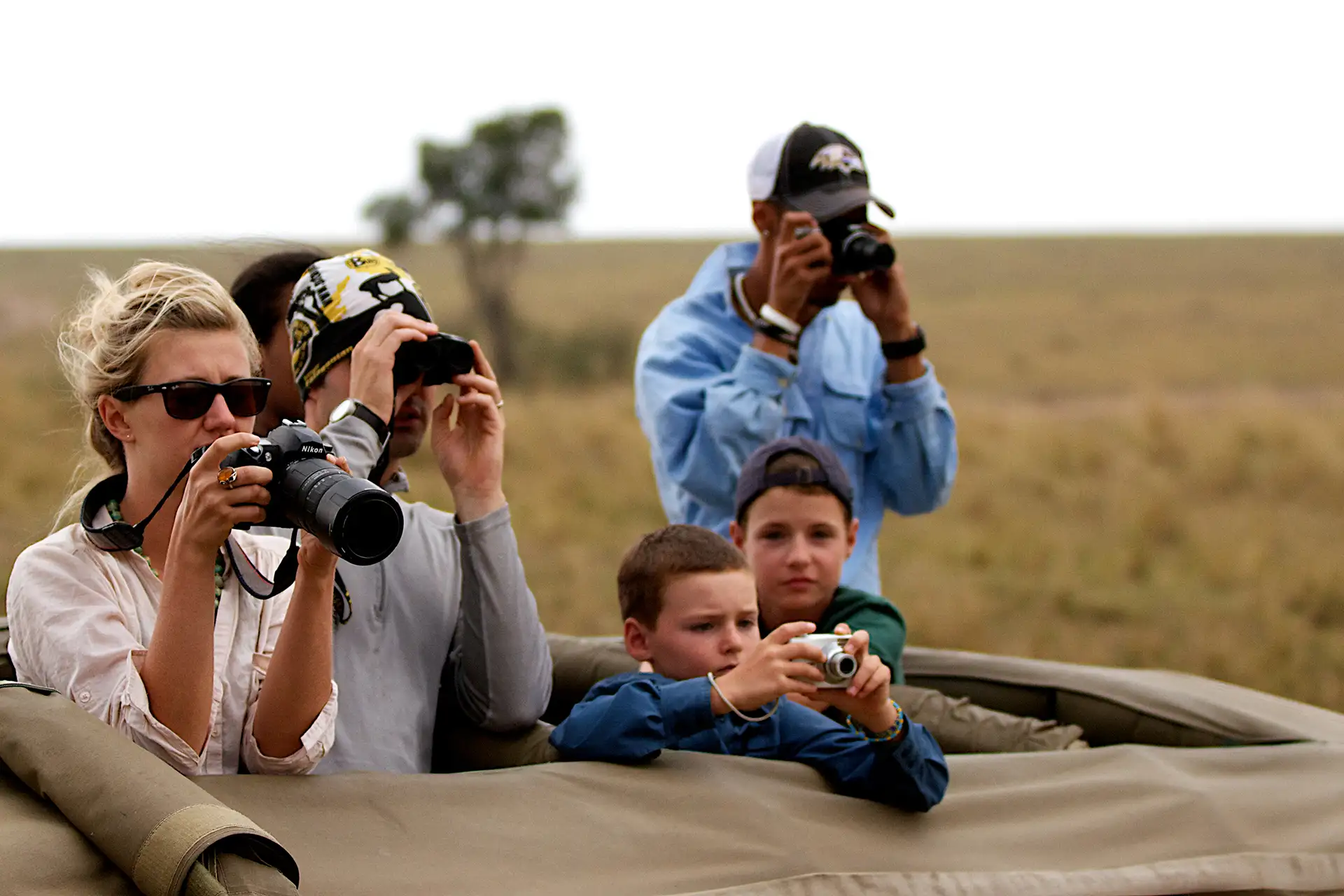 Family taking photos from a car on a Safari
