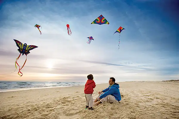 A little boy and his father flying kites on South Padre Island.