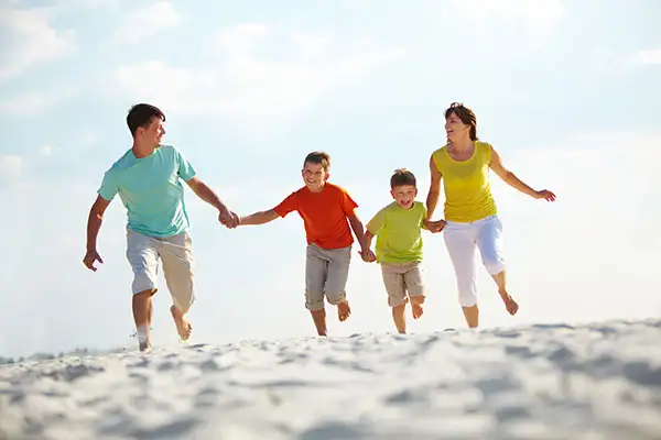 A family running along the beach.