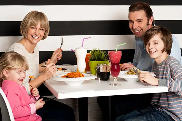 A family of four enjoying a nice meal out.