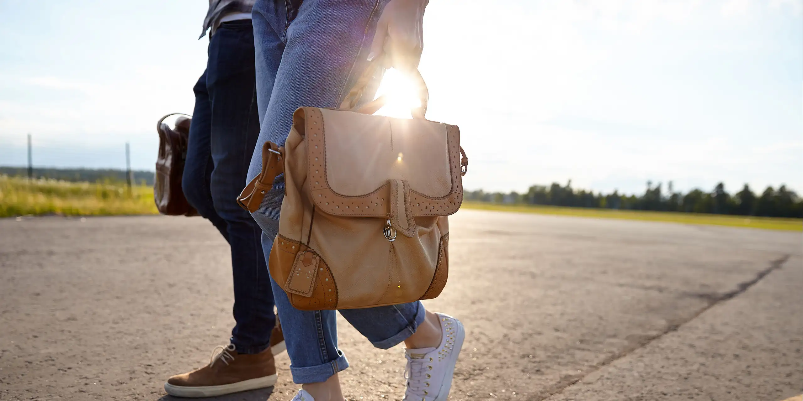 couple walking carrying travel bag runway; Courtesy begalphoto/Shutterstock