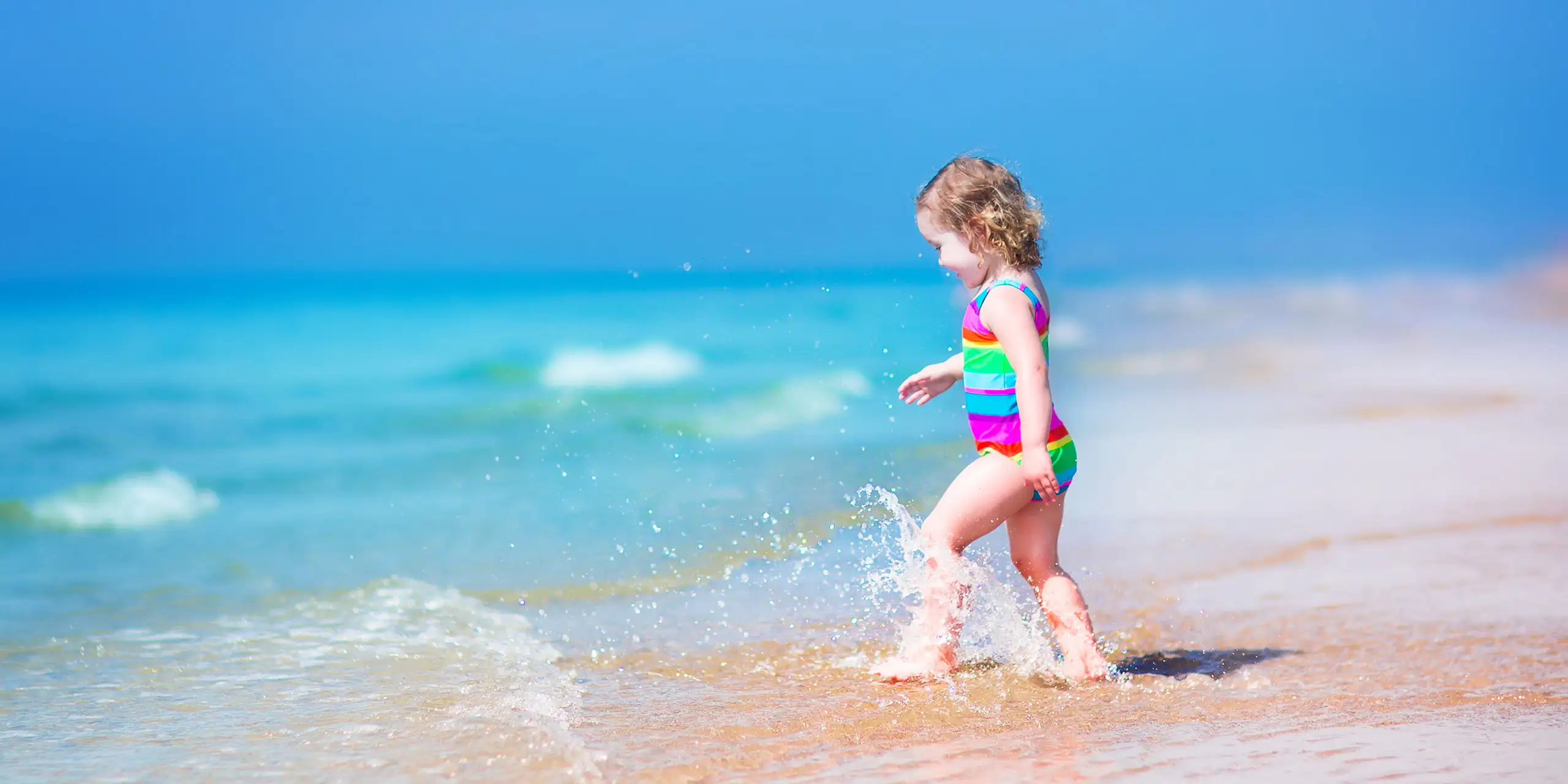 Toddler on the Beach; Courtesy of FamVeld/Shutterstock.com