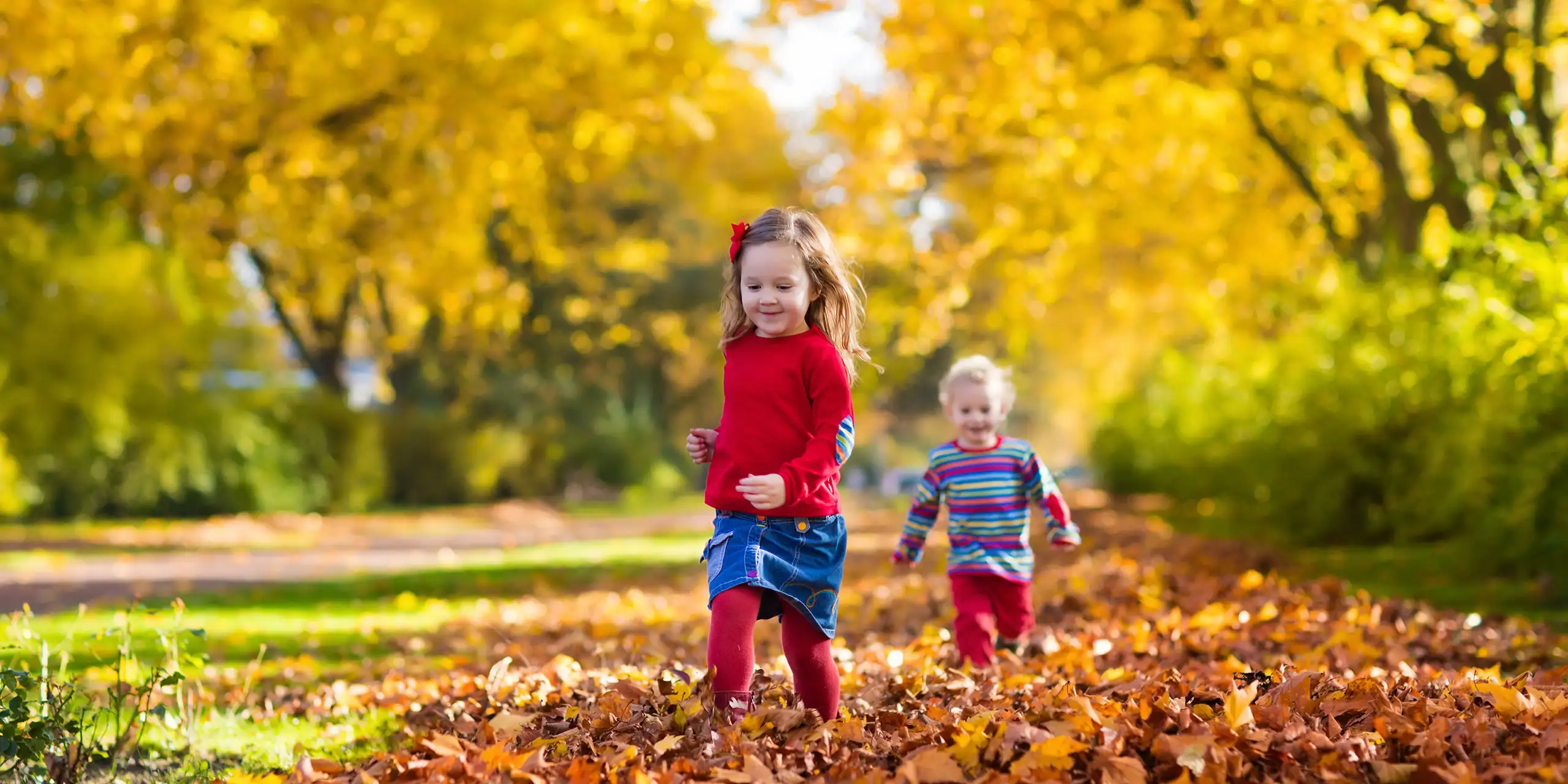 Kids Playing in Fall Leaves; Courtesy of FamVeld/Shutterstock.com