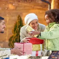 family gift giving holidays snowing; Courtesy of Lucky Business /Shutterstock