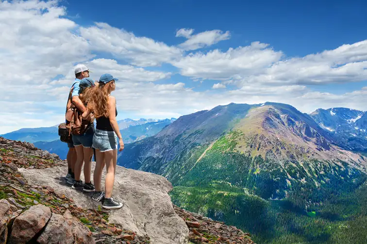 family on hiking trip, on top of mountain rock. View from Trail Ridge Road.Rocky Mountains National Park, Colorado ; Courtesy of margaret.wiktor/Shutterstock
