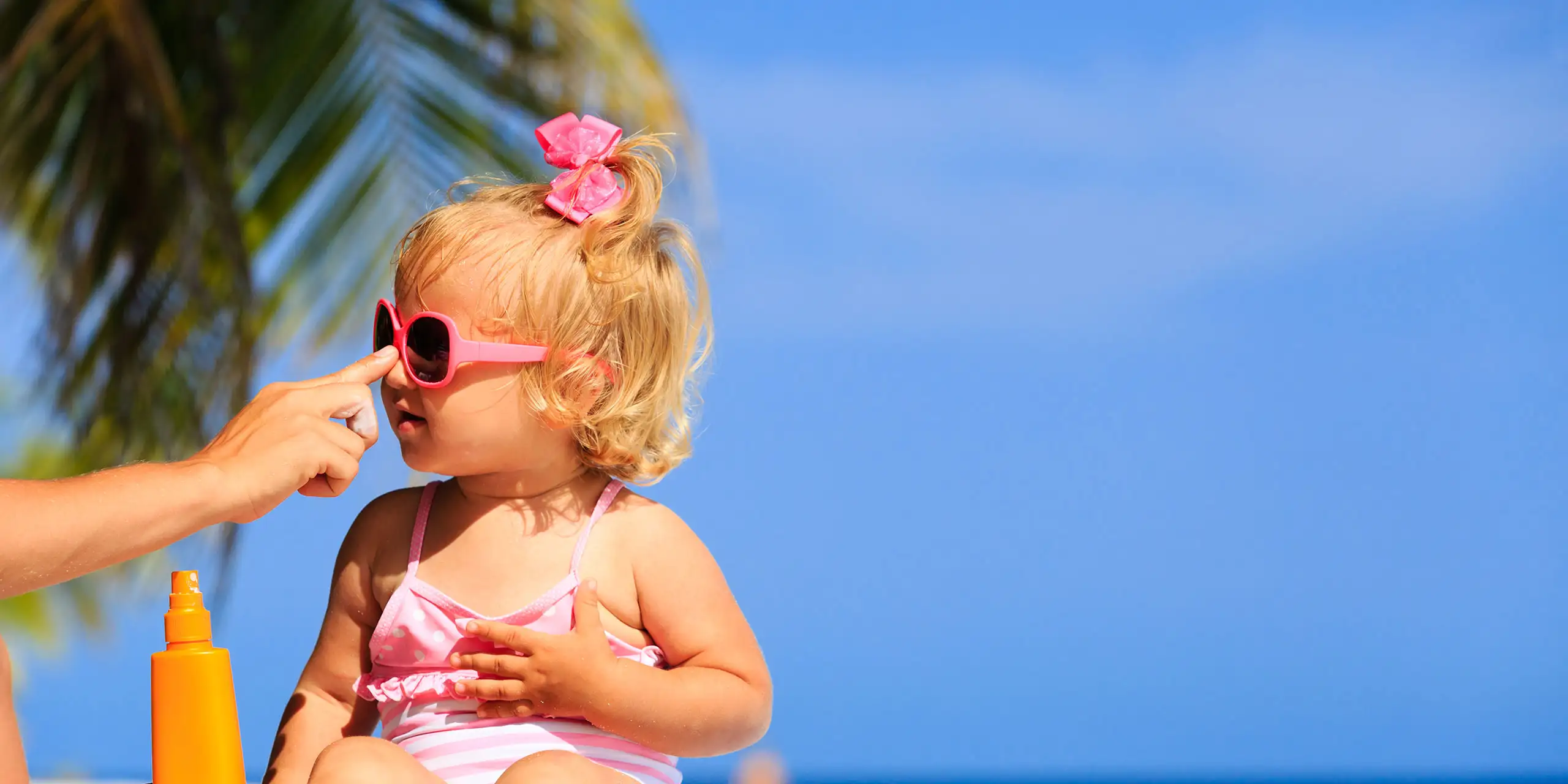 Baby Getting Sunscreen Applied; Courtesy of NadyaEugene/Shutterstock.com