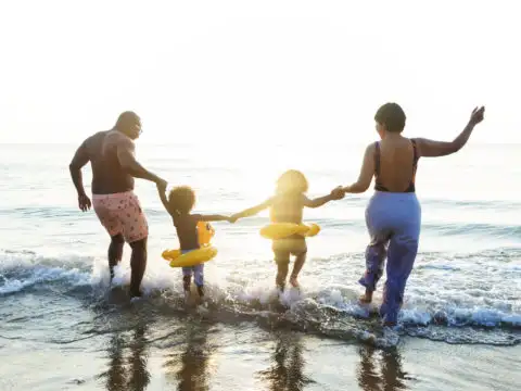 Family jumping into waves on the beach