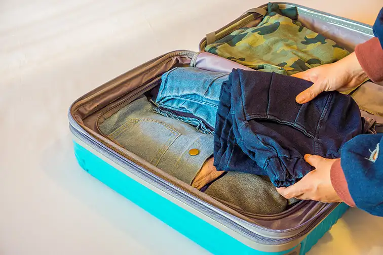 clothes folded in suitcase: Courtesy of JoeyPhoto/Shutterstock