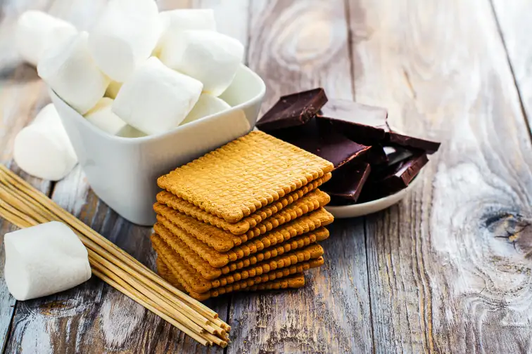 Smores dessert ingredients on wooden table. Picnic or camp concept. Courtesy of Ekaterina Markelova/Shutterstock