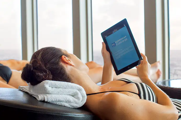 Woman Using iPad on Cruise Ship; Courtesy of Norwegian Cruise LIne