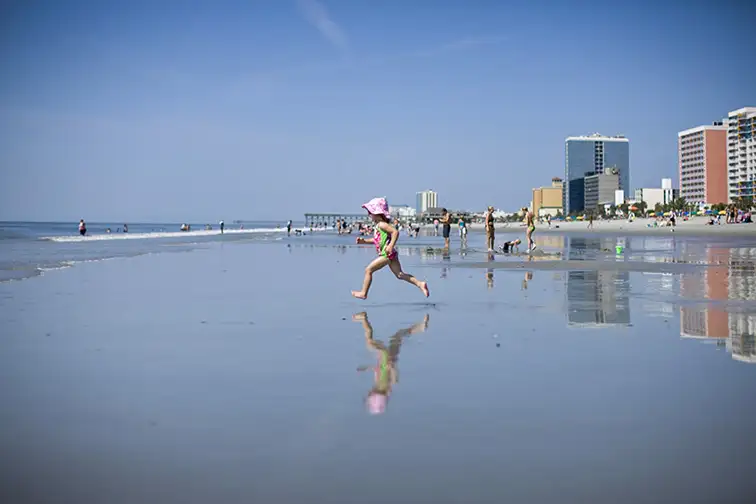 Girl running into the waves; Courtesy of MBACVB
