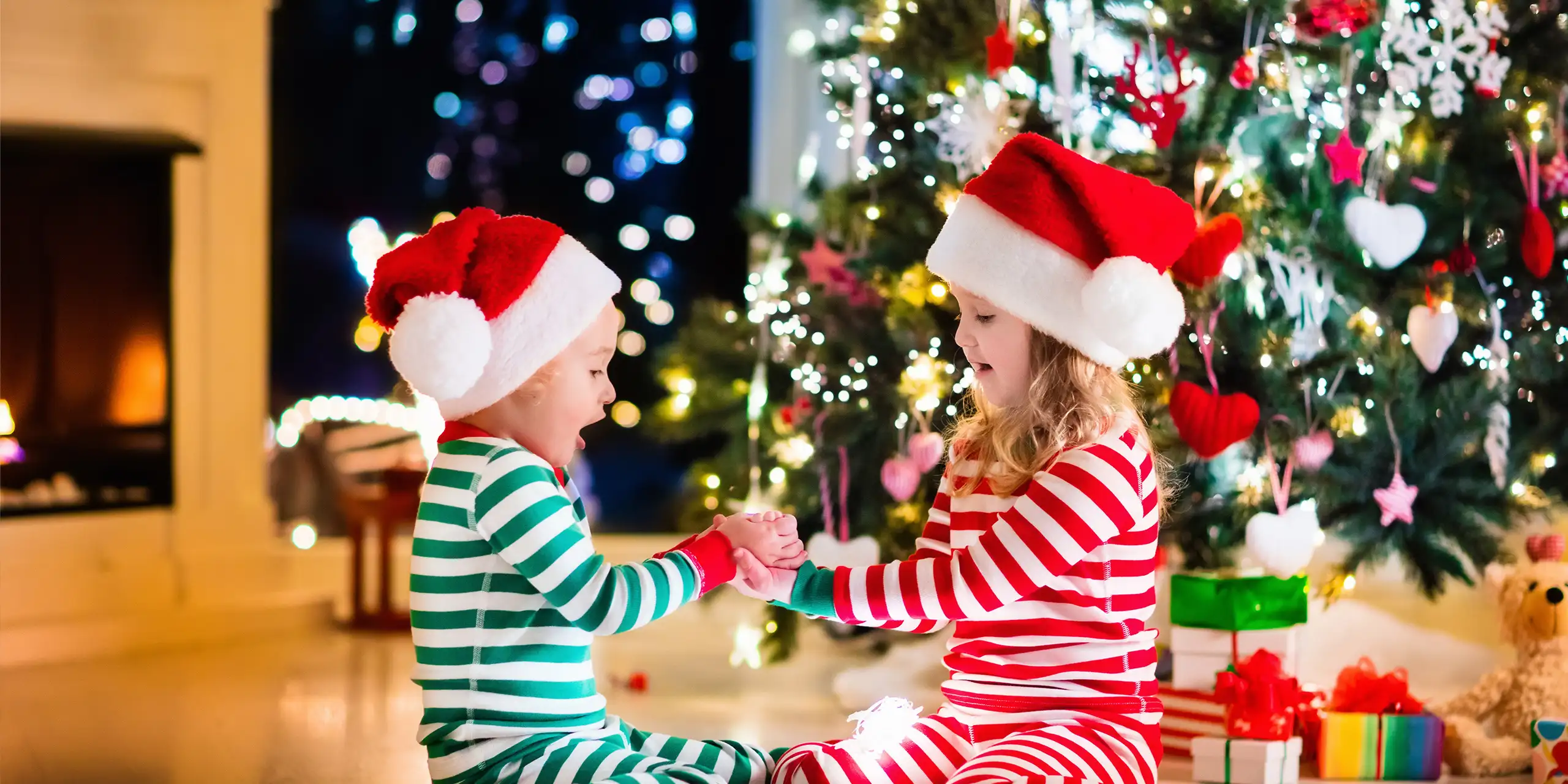 Happy little kids in matching red and green striped pajamas; Courtesy of Famveld/Shutterstock