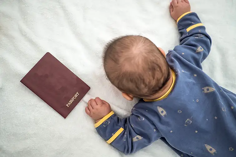 lat lay new born baby and passport; Courtesy of bookzv/Shutterstock