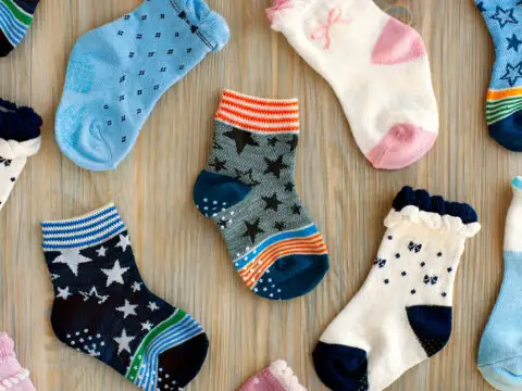 baby socks flat lay on a table top; Courtesy of Evgeniya369/Shutterstock