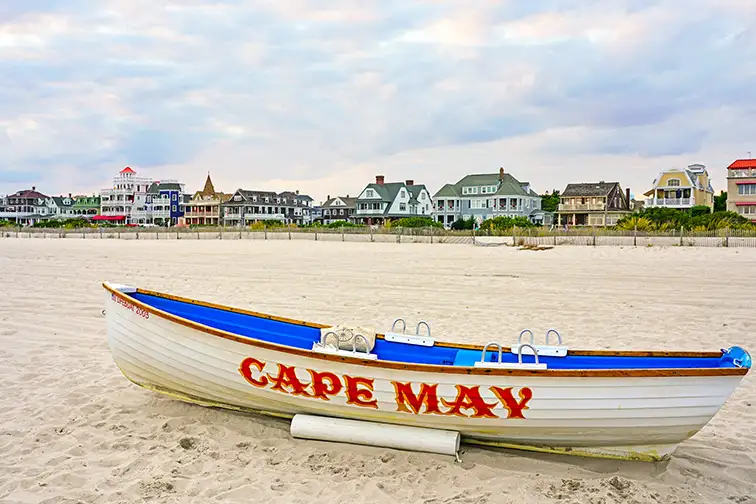 View of a boat with a Cape May sign on the beach in Cape May, New Jersey, USA.; Courtesy of EQRoy/Shutterstock