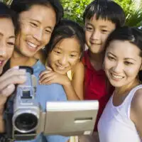 Family Looking at Video Camera Screen; Courtesy of sirtravelalot/Shutterstock