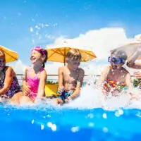 Children play fun with splashes on the side of the pool at the resort; Courtesy of YanLev/Shutterstock