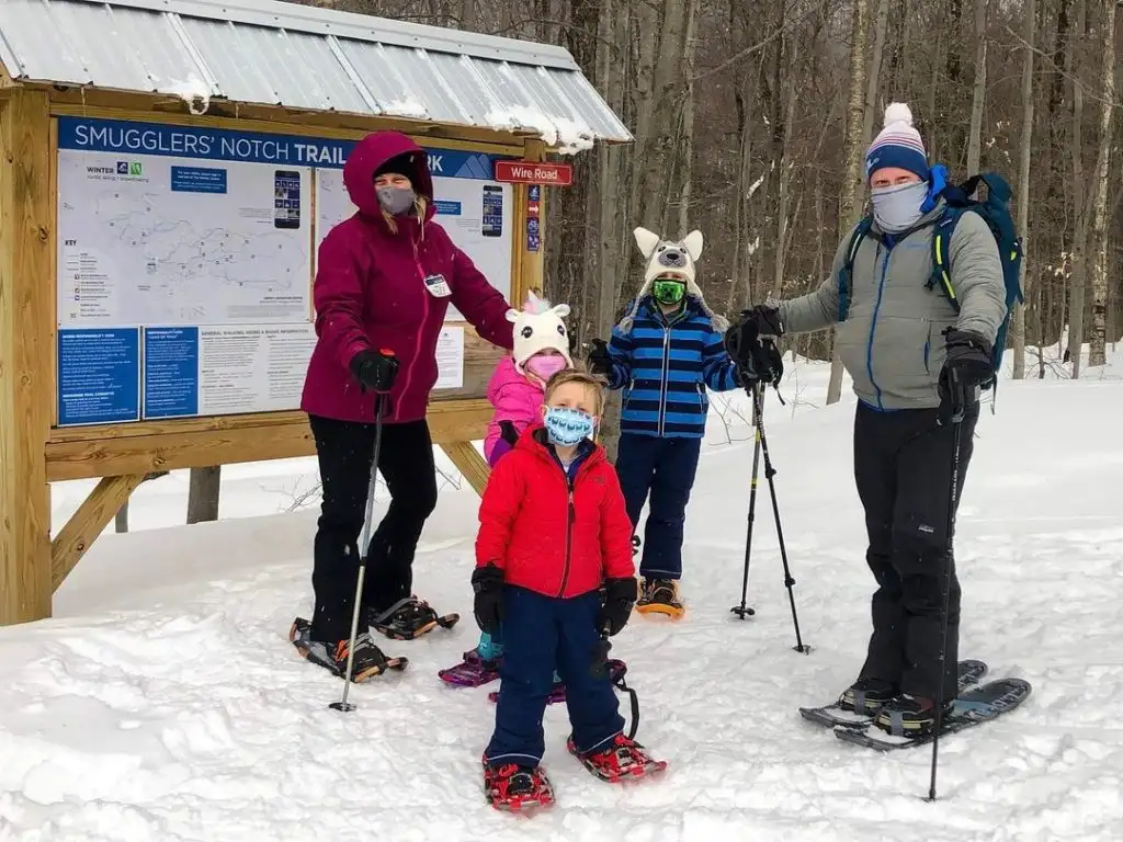 A family at a hiking trailhead at Smuggler's Notch